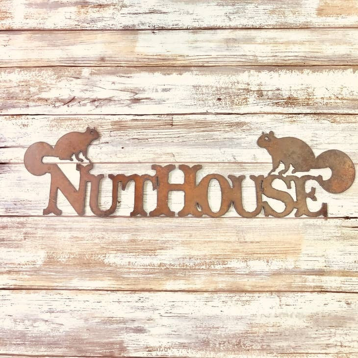 Rustic metal cabin sign reading “Welcome to the Nuthouse” with squirrel design