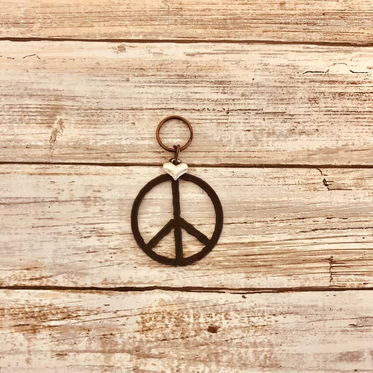 Metal keychain featuring a rustic-style peace symbol design