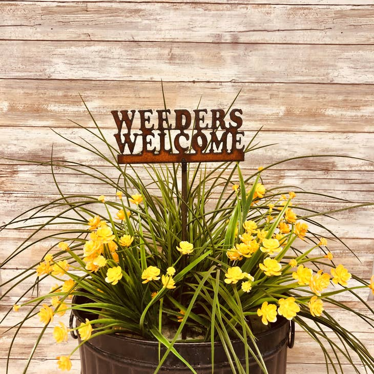 Rustic metal garden stake with “Weeders Welcome” engraved message