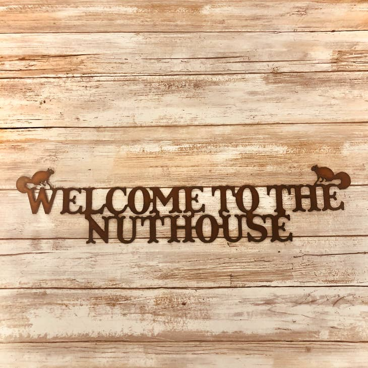 Funny rustic metal sign reading “Welcome to the Nuthouse” for cabin or porch
