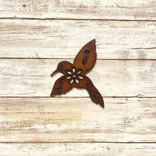 Rustic metal bird featuring a flower, serving as decorative garden art and a charming addition to outdoor spaces.